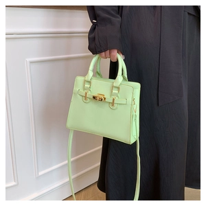 Detail of mint green crossbody bag featuring golden metal clasp and adjustable strap