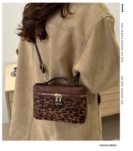 Détail du sac bandoulière imprimé léopard avec zips dorés et bandoulière en cuir