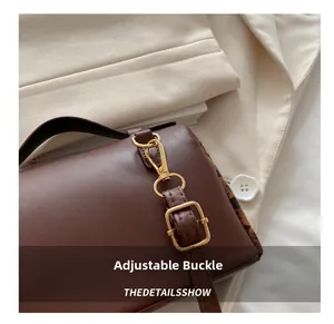 Détail de la boucle dorée réglable et cuir marron foncé de haute qualité sur la sacoche