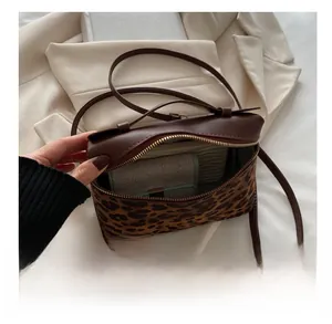 Vue intérieure d'un sac bandoulière léopard montrant l'espace de rangement pour accessoires