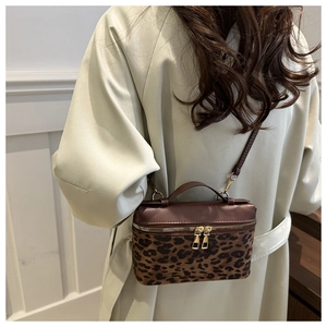 Détail du sac bandoulière tendance à motif léopard et cuir porté à l'épaule pour l'échelle