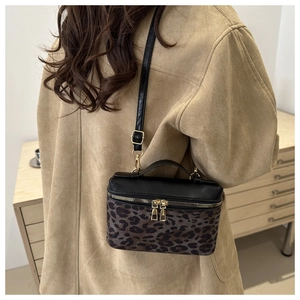 Sac à bandoulière léopard tendance avec fermeture éclair dorée porté par un mannequin