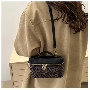 Sac bandoulière boîte à imprimé léopard porté avec un manteau beige élégant et moderne