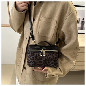 Détail du sac boîte léopard avec fermetures dorées et bandoulière réglable chic