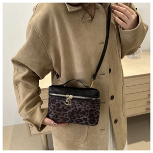 Détail du sac bandoulière tendance à motif léopard avec double fermeture éclair dorée