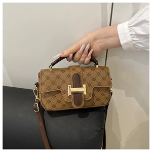 Detail of vintage brown floral print handbag with leather trim and gold hardware