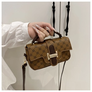 Detailed close-up of retro printed leather handbag featuring a golden H-shaped clasp