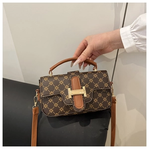 Detail of vintage floral pattern bag with golden metal buckle and leather handle
