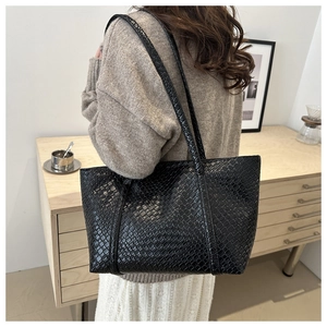 Close-up of black woven tote bag with large capacity and stylish texture details