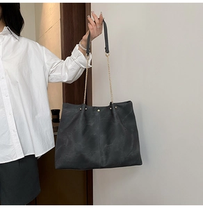 Detail der dunkelgrauen Shopper Tasche mit Vintage-Textur und goldener Kettenschulter