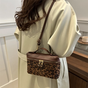Sac bandoulière boîte chic imprimé léopard avec détails dorés et design bicolore
