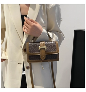 Detail of a vintage-style contrast color shoulder bag with textured woven pattern