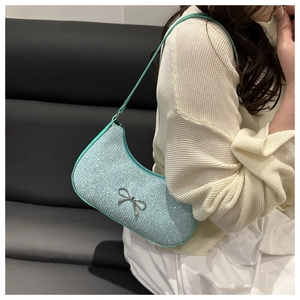 Detail of light blue sequin shoulder bag with a silver metal bow buckle accent