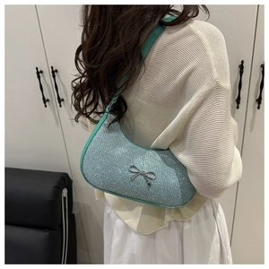 Close-up of mint blue glitter shoulder bag featuring a silver metal bow accent