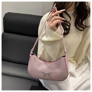 Detail of pink rhinestone baguette bag featuring a sparkling silver bow and metal zipper