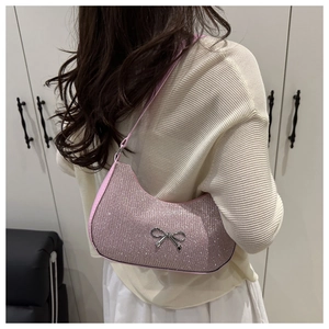 Detail of pink rhinestone hobo bag with a silver metal bow accent and shimmery texture
