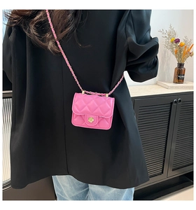 Detailed view of pink quilted mini crossbody bag with gold floral clasp and chain strap