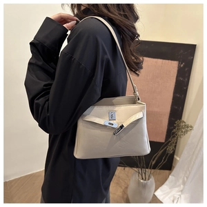 Model view of beige leather tote bag with classic silver twist-lock buckle closure