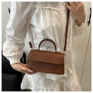 Detail of a brown shoulder bag with mixed texture and elegant crossbody strap