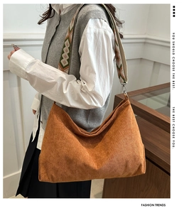 Detail of orange corduroy tote bag with colorful geometric jacquard wide strap and metal hooks