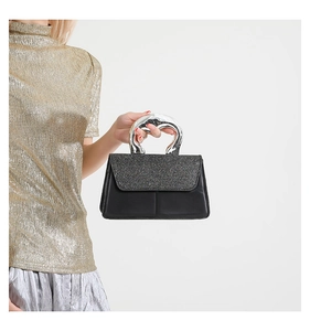 Détail du sac à main noir à rabat scintillant avec poignée en métal argenté