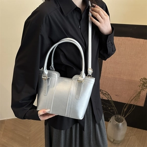 Silver metallic bucket handbag with top handles and adjustable strap for modern commuting