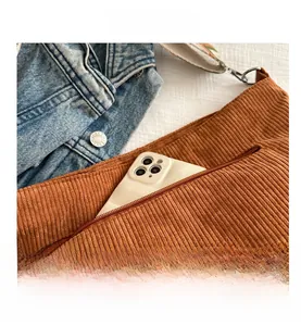 Detail of caramel corduroy tote showing back zipper pocket with phone and woven strap