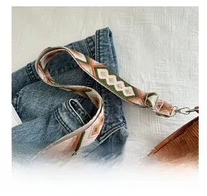Close-up of a colorful geometric woven shoulder strap with metallic silver hooks