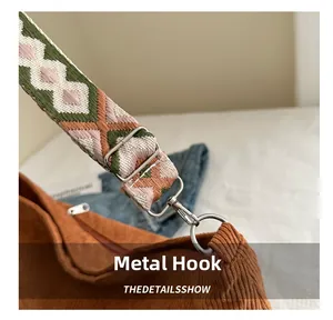 Detail of silver hardware hook and colorful geometric woven strap on corduroy tote bag