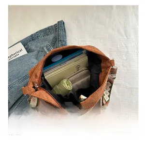 Internal view of brown corduroy tote bag showing large capacity for books and umbrella