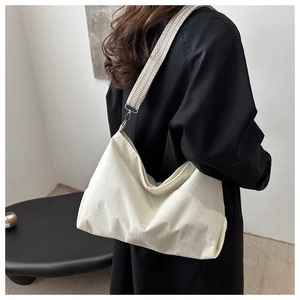 Detail of white corduroy tote bag with ethnic geometric woven shoulder strap and metal hooks