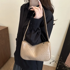 Minimalist beige woven underarm bag with checkerboard texture and golden zipper