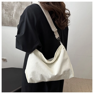 Close-up of white corduroy tote bag with grey herringbone patterned shoulder strap