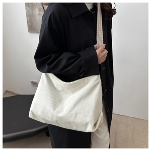 Detail view of white corduroy tote bag with wide geometric patterned shoulder strap