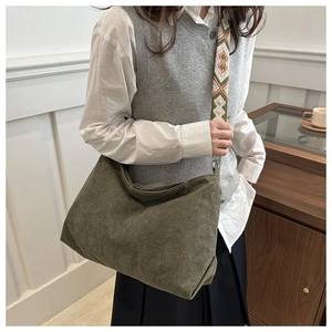 Detail view of olive green corduroy tote bag with geometric embroidered wide shoulder strap