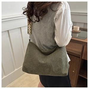 Detail of dark green corduroy fabric and ethnic style geometric woven strap on tote bag