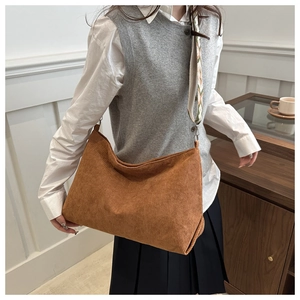 Detailed macro view of brown corduroy tote bag featuring an embroidered ethnic shoulder strap