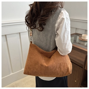 Close-up of caramel brown corduroy tote bag with rainbow geometric woven shoulder strap