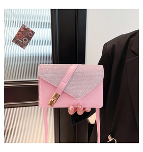 Close-up of pink crossbody bag with sparkling rhinestone flap and golden twist lock