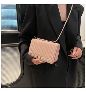 Détail du sac bandoulière matelassé rose clair avec chaîne dorée et fermoir en métal
