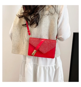Detail of red leather crossbody bag with sequin patchwork and golden turn-lock closure