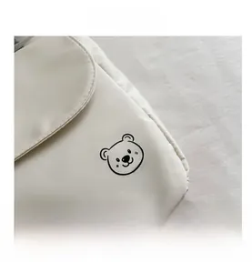 Close-up of white canvas shoulder bag featuring a cute black linear bear print and BEAR text