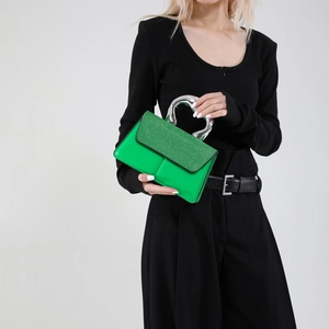 Sac à bandoulière vert vif avec poignée coeur métallique et rabat pailleté sur modèle