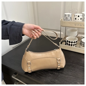 Dettaglio della borsa baguette beige che mostra la pelle PU lucida e la fibbia in metallo