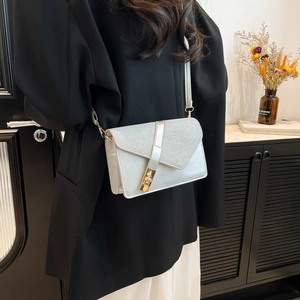 Elegant silver crossbody bag with glitter geometric flap and gold twist lock clasp