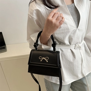 Sac bandoulière noir élégant avec nœud doré et poignée nouée pour femmes stylées