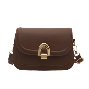 Classic dark brown saddle shoulder bag with gold horseshoe buckle on white background