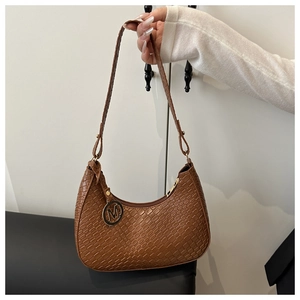 Nahaufnahme der braunen Hobo-Tasche mit Krokodilprägung und goldenem M-Anhänger