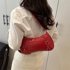 Borsa baguette rossa lucida con occhielli in metallo e rivetti vista sul retro indossata
