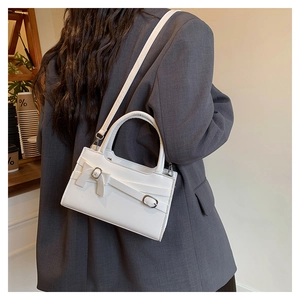 Detailed back view of a white leather crossbody bag with an elegant bow accent
